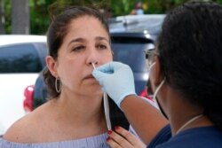 Raquel Heres gets a COVID-19 test to be able to travel overseas, July 31, 2021, in North Miami, Fla. Federal health officials say Florida has reported 21,683 new cases of COVID-19, the state's highest one-day total since the start of the pandemic.