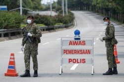 Soldiers in face masks maintain a checkpoint in Putrajaya, Malaysia, March 22, 2020. Malaysian government issued a movement order to the public starting from March 18 until March 31 to stop the spread of the new coronavirus.