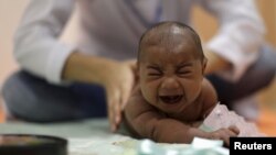 FILE - Pietro Rafael, who has microcephaly, reacts to stimulus during an evaluation session with a physiotherapist at the Altino Ventura rehabilitation center in Recife, Brazil, Jan. 28, 2016. 