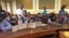 A Harare resident displays a sample of dirty water in a bottle next to him during a meeting with the city's mayor at a meeting at Town House, in Harare, Zimbabwe, Dec. 29, 2017. (S. Mhofu/VOA)