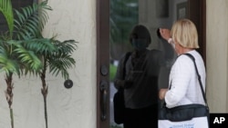 FILE - A census taker knocks on the door of a residence Aug. 11, 2020, in Winter Park, Fla.