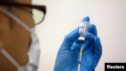 A staff member prepares the Moderna COVID-19 vaccine to be administered at a mass vaccination center in Tokyo, Japan, on May 24, 2021. (Carl Court/Reuters)