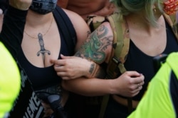 People lock arms while facing a police line during a protest in response to the police killing of George Floyd outside the CNN Center on May 29, 2020 in Atlanta, Georgia.