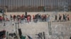 Migranti stoje američkog graničnog zida nakon što su ih zadržale američke imigracione vlasti, 27. decembar 2023.