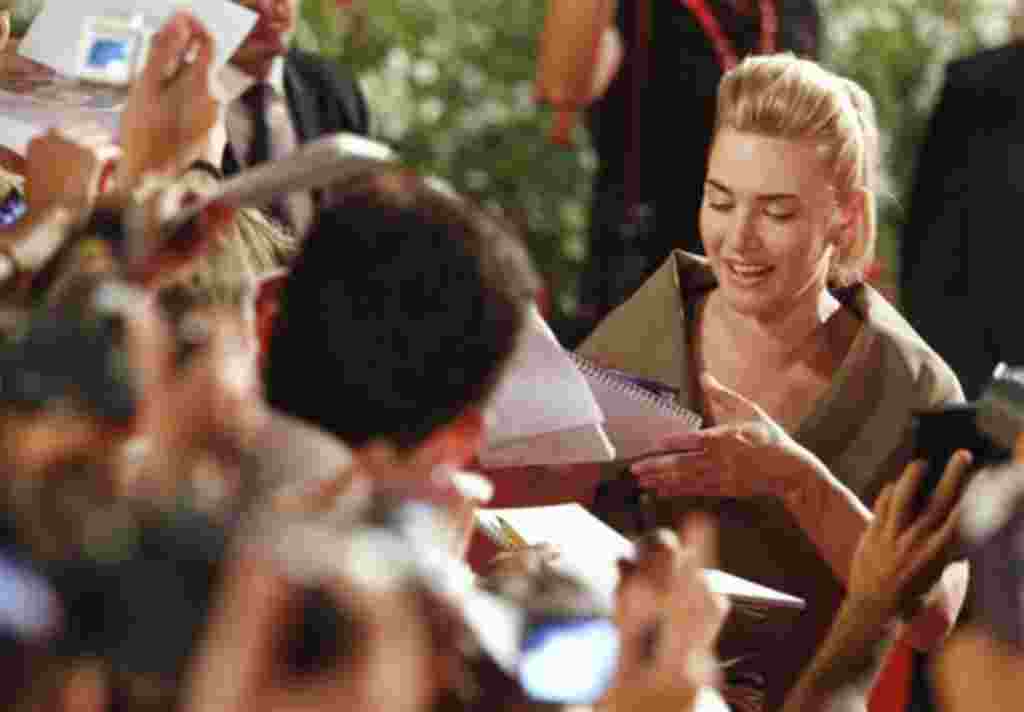 La actriz británica Kate Winslet firma autógrafos a su llegada a la alfombra roja para el estreno de 'Carnicería' en la edición 68 del Festival de Cine de Venecia en Italia,