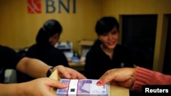 Transaksi keuangan di Bank Negara Indonesia (BNI) di Jakarta (15/7/2013). BNI Merupakan salah satu dari delapan bank yang menyalurkan Kredit Usaha Rakyat untuk meringankan beban UKM.