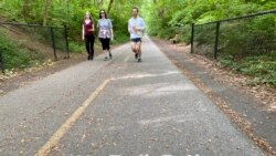 Joggers and walkers practice social distancing on Capital Crescent trail which connects Bethesda, Maryland, to Washington, D.C., May 27, 2020.