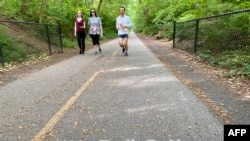 Joggers and walkers practice social distancing on Capital Crescent trail which connects Bethesda, Maryland, to Washington, D.C., May 27, 2020.