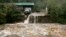 Una casa y un carro corren peligro de ser arrastrados por el agua de la quebrada Coal cerca de Golden, en Colorado.