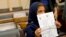 Nine-year-old Nabila Rehman holds a photo with a drawing she made depicting a drone strike that killed her grandmother, Oct. 29, 2013.
