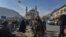 Seornag anggota pasukan Taliban berdiri di samping penjual makanan burung di salah satu pasar di Kabul, pada 3 Desember 2021. (Foto: AFP/Arman Sahel)