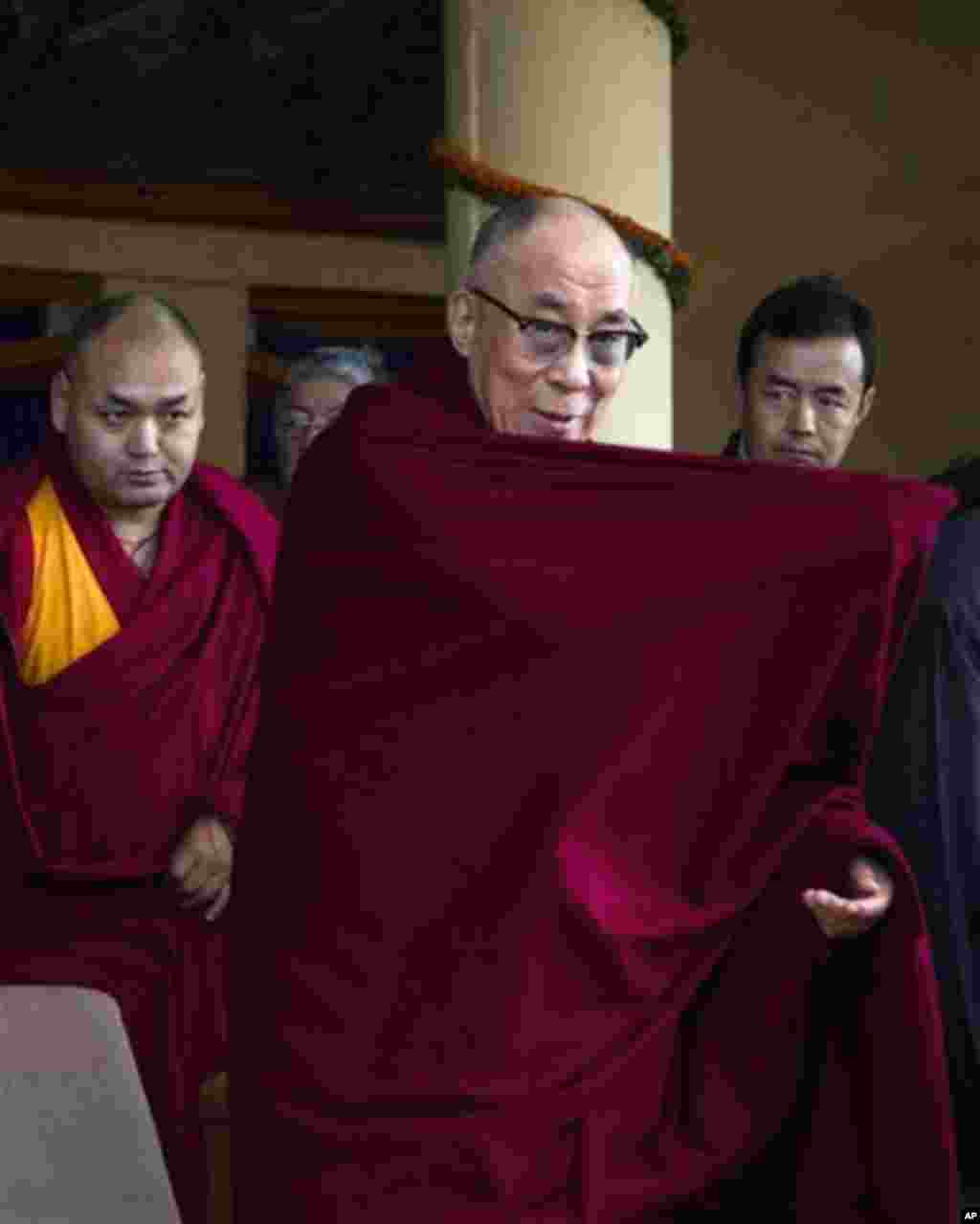 Tibetan spiritual leader the Dalai Lama adjusts his robe upon arrival at a gathering to mark the anniversary of an unsuccessful revolt against China in 1959, in Dharmsala, India, Saturday, March 10, 2012. The head of Tibet's government in exile has blamed