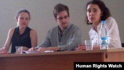 Edward Snowden (tengah) didampingi Sarrah Harrison dari WikiLeaks (kiri) di bandara Moskow (12/7).