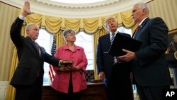 President Donald Trump watches as Vice President Mike Pence administers the oath of office to Attorney General Jeff Sessions, accompanied by his wife Mary, Feb. 9, 2017, in the Oval Office of the White House in Washington.