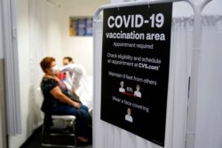 FILE - A patient receives a shot of the Moderna COVID-19 vaccine at a CVS Pharmacy branch in Los Angeles, March 1, 2021.
