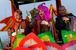 Actor Charlie Day and his wife actress Mary Elizabeth Ellis throw beads in the Krewe of Orpheus along the Uptown parade route during Mardi Gras celebrations in New Orleans, Feb. 24, 2020.