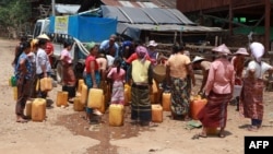 Люди племени Кайя собираются у раздачи питьевой воды благотворительной организацией в лагере для внутренне перемещенных лиц в городке Демосо на востоке штата Кайя в Мьянме, 29 апреля 2024 года
