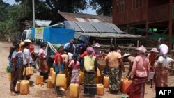 (FILES) This photo taken on April 29, 2024 shows Kayah people gathering at a delivery of drinking water by the charity Clean Yangon at a camp for internally displaced people in Demoso township, in Myanmar's eastern Kayah state.