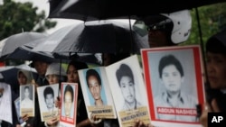 Para kerabat berdemo di luar Kedutaan Besar AS sambil membawa foto para aktivis yang hilang dan korban pelanggaran HAM yang diduga dilakukan oleh sejumlah anggota KOPASSUS pada 1997-1998, 27 Juli 2010. (Foto: Dita Alangkara/AP) 