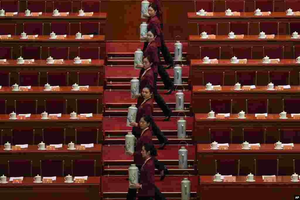 Hostesses fill up tea cups for the leaders before the opening session of the Chinese People&#39;s Political Consultative Conference at the Great Hall of the People in Beijing.