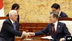 U.S. Vice President Mike Pence, left, shakes hands with South Korean President Moon Jae-in during their meeting at the presidential office Blue House in Seoul Thursday, Feb. 8, 2018. 