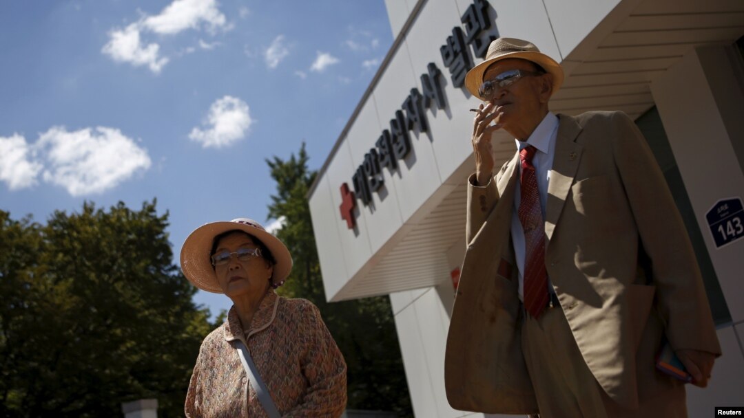 Oh Seong-ik (kanan), 83, yang memiliki keluarga di Korea Utara, merokok setelah menyiapkan dokumen untuk reuni, di luar kantor Palang Merah di Seoul, Korea Selatan (7/9). (Reuters/Kim Hong-Ji)