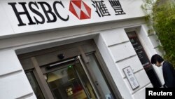 FILE - A worker uses an ATM at a branch of HSBC in Chinatown in central London, June 9, 2015.