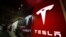 Sebuah tanda berlogo perusahaan ditampilkan di luar toko Tesla di Cherry Creek Mall di Denver. (Foto: AP)