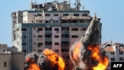 Fire balls erupt at the Jala Tower as it is hit by Israeli airstrikes in Gaza City, May 15, 2021. The building housed media offices of the Associated Press and Al-Jazeera, among others. 