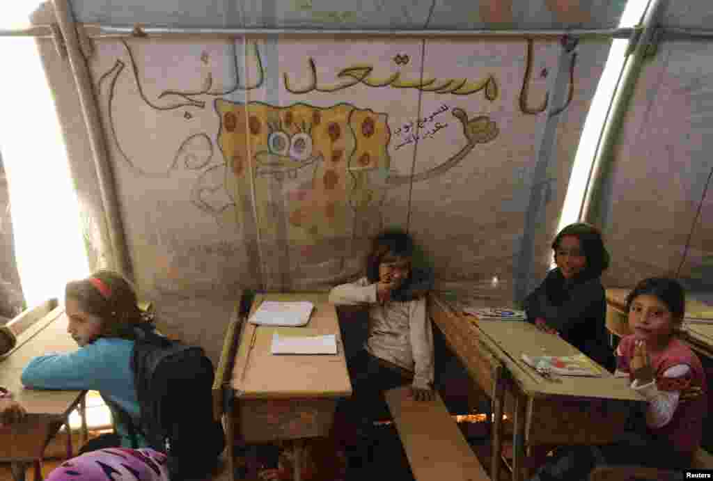 Children attend a class inside a makeshift school in the Bab Al-Salam refugee camp in Azaz, Oct. 27, 2014.