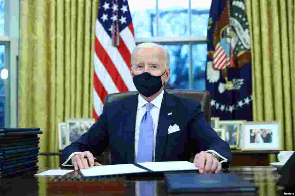 U.S. President Joe Biden signs executive orders in the Oval Office of the White House in Washington, after his inauguration as the 46th President of the United States, U.S., January 20, 2021.