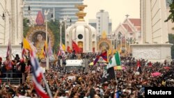 Pro-democracy demonstrators flash a three-finger salute while sitting on the ground during a Thai anti-government mass protest, on the 47th anniversary of the 1973 student uprising, in Bangkok, Thailand October 14, 2020. REUTERS/Soe Zeya Tun