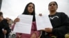 Women hold letters from the US embassy after their visa appointments was cancelled in Bogota on Jan. 27, 2025. 