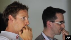 Pebalap Jenson Button, kiri, berdiri di sebelah mekanik tim McLaren (foto: dok.).