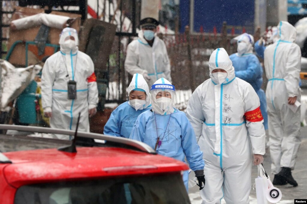 2022年3月14日，中国吉林省长春市新冠肺炎疫情爆发后，身着防护服的医务人员在雪地中行走，进入被封锁的住宅小区进行核酸检测(photo:VOA)