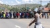 Um veículo blindado militar bloqueia a estrada enquanto manifestantes tentam chegar ao posto fronteiriço de Ressano Garcia, entre Moçambique e a África do Sul, 13 novembro 2024