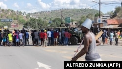 Um veículo blindado militar bloqueia a estrada enquanto manifestantes tentam chegar ao posto fronteiriço de Ressano Garcia, entre Moçambique e a África do Sul, 13 novembro 2024