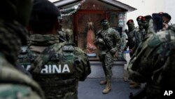 A soldiers poses for a photo with a statue of the Virgin of Guadalupe before the start of the annual Independence Day military parade in Mexico City's main square, known as the Zocalo, Sept. 16, 2017. Mexico is considering a law to give the military more 