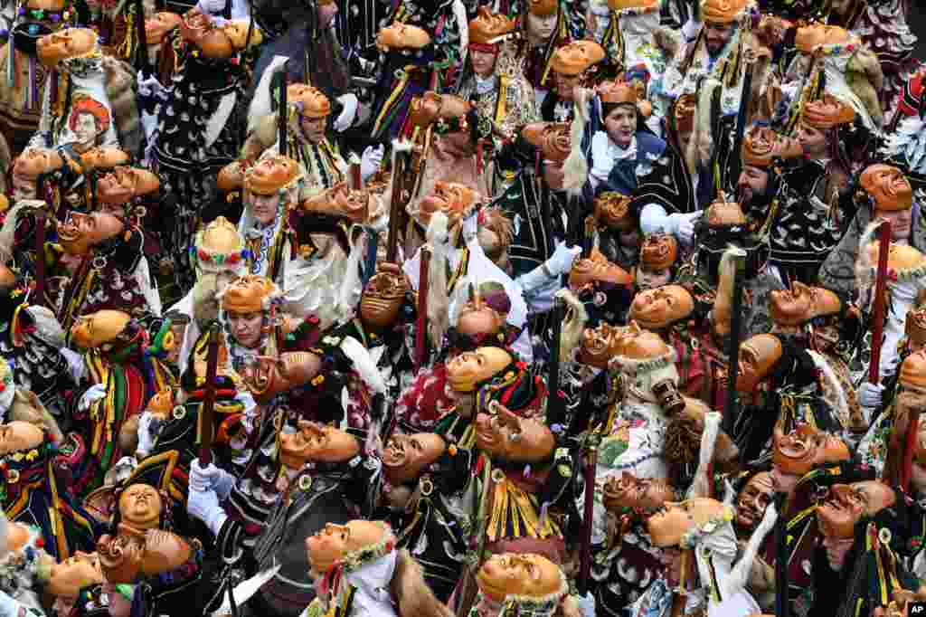 Masked revelers prepare to take part in the carnival in Rottweil, Germany.