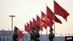 FILE - Chinese People's Liberation Army soldiers patrol at Tiananmen Square in Beijing on March 7, 2024.