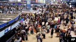 Passengers line up at the Delta Air Lines check-in counter at Narita international airport in Narita, east of Tokyo, Aug. 9, 2016. 