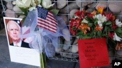 A makeshift memorial builds at the office of Arizona Republican Sen. John McCain, Aug. 26, 2018, in Phoenix. 