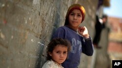 Two Palestinian refugee children lean on the wall of a house in Gezirat al-Fadel village, Sharqiya, about 150 kilometers (93 miles) east of Cairo, Egypt, May 17, 2013.