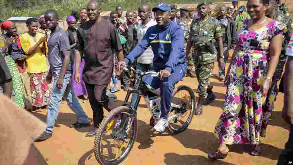 Pierre Nkurunziza arrive à bicyclette, accompagné par la Première dame burundaise, Denise Bucumi Nkurunziza,  pour voter, Ngozi, 21 juillet 2015. 