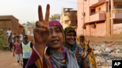 Sudanese protesters flash victory signs and shout slogans, as they march during a protest against the military council, in Khartoum, Sudan, June 27, 2019. 
