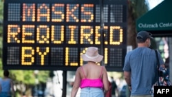 People walk along King St. on July 18, 2020 in Charleston, South Carolina.