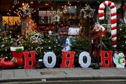 Una mujer pasa junto a una exhibición de temporada de una tienda de vinos, mientras el gobierno británico impone restricciones escalonadas más estrictas por la pandemia de COVID-19, en Londres, el 20 de diciembre de 2020.