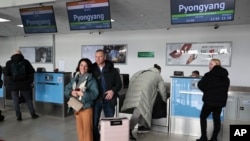 Sepasang suami dan istri Rusia berfoto setelah lapor masuk untuk menaiki pesawat ke Korea Utara di bandara internasional di Vladivostok, Rusia, 9 Februari 2024. (Foto: AP Photo)