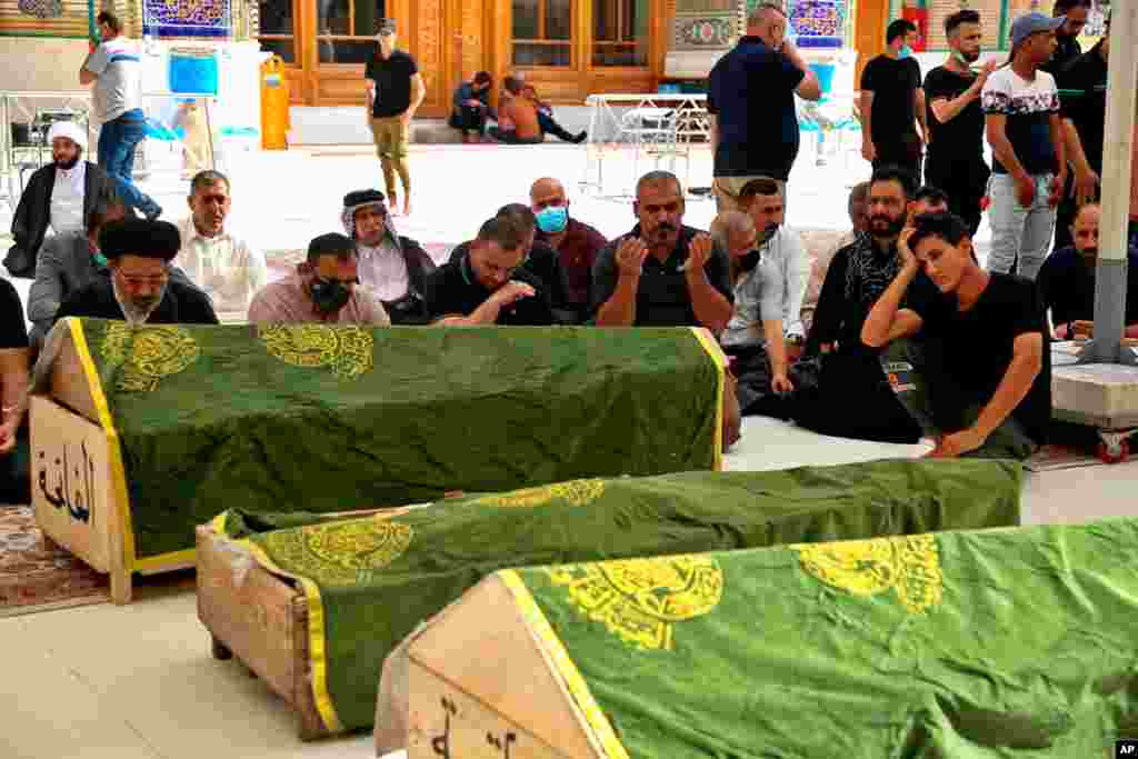 Mourners pray for coronavirus patients who were killed in a hospital fire, during their funeral at the Imam Ali shrine in Najaf, Iraq.