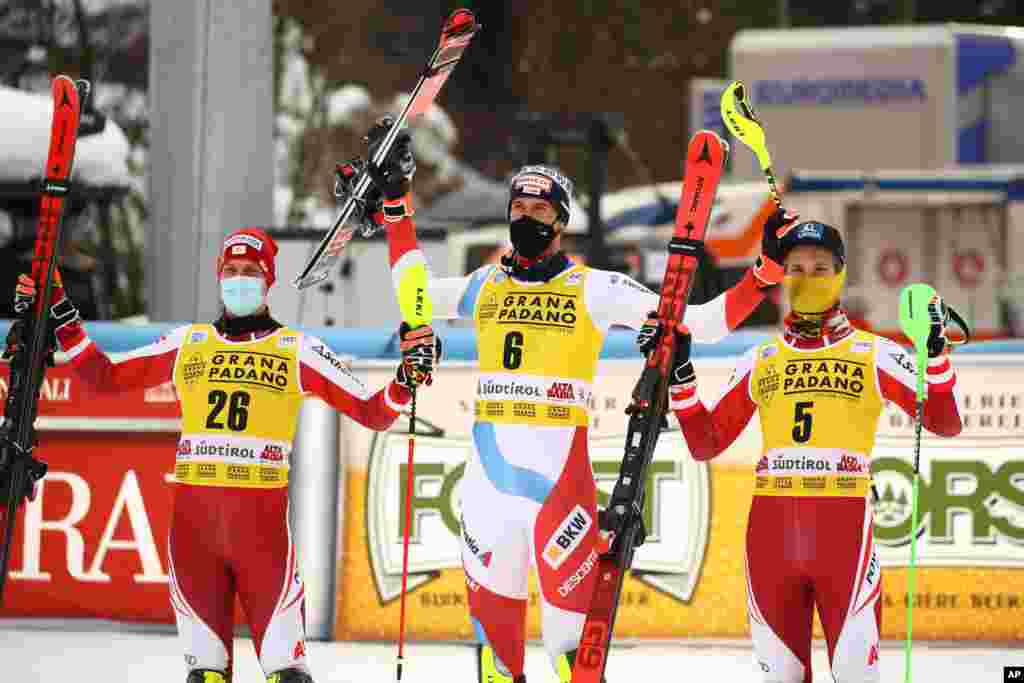 ورزشکار سوئیسی (وسط) و دو اتریشی موفقیت خود در مسابقات جام جهانی اسکی آلپاین که در ایتالیا برگزار می‌شود را جشن گرفته‌اند. 
